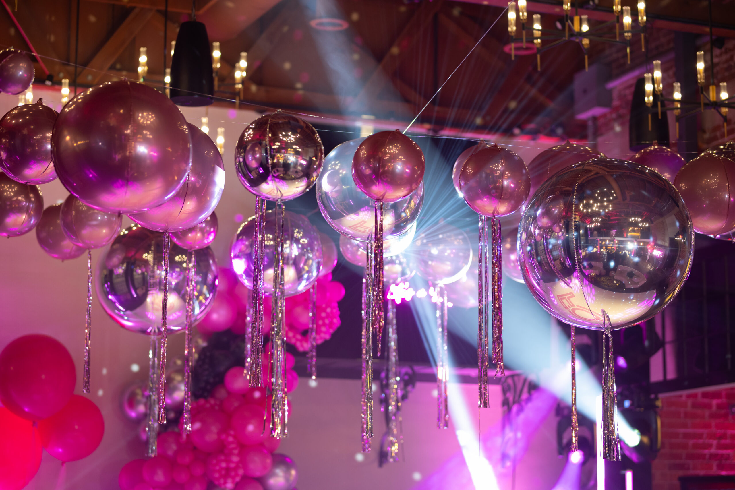 113JanBirchIN0A2501 - Bronson Hospitality Hanging pink and silver balloons with metallic ribbons at a colorful party venue