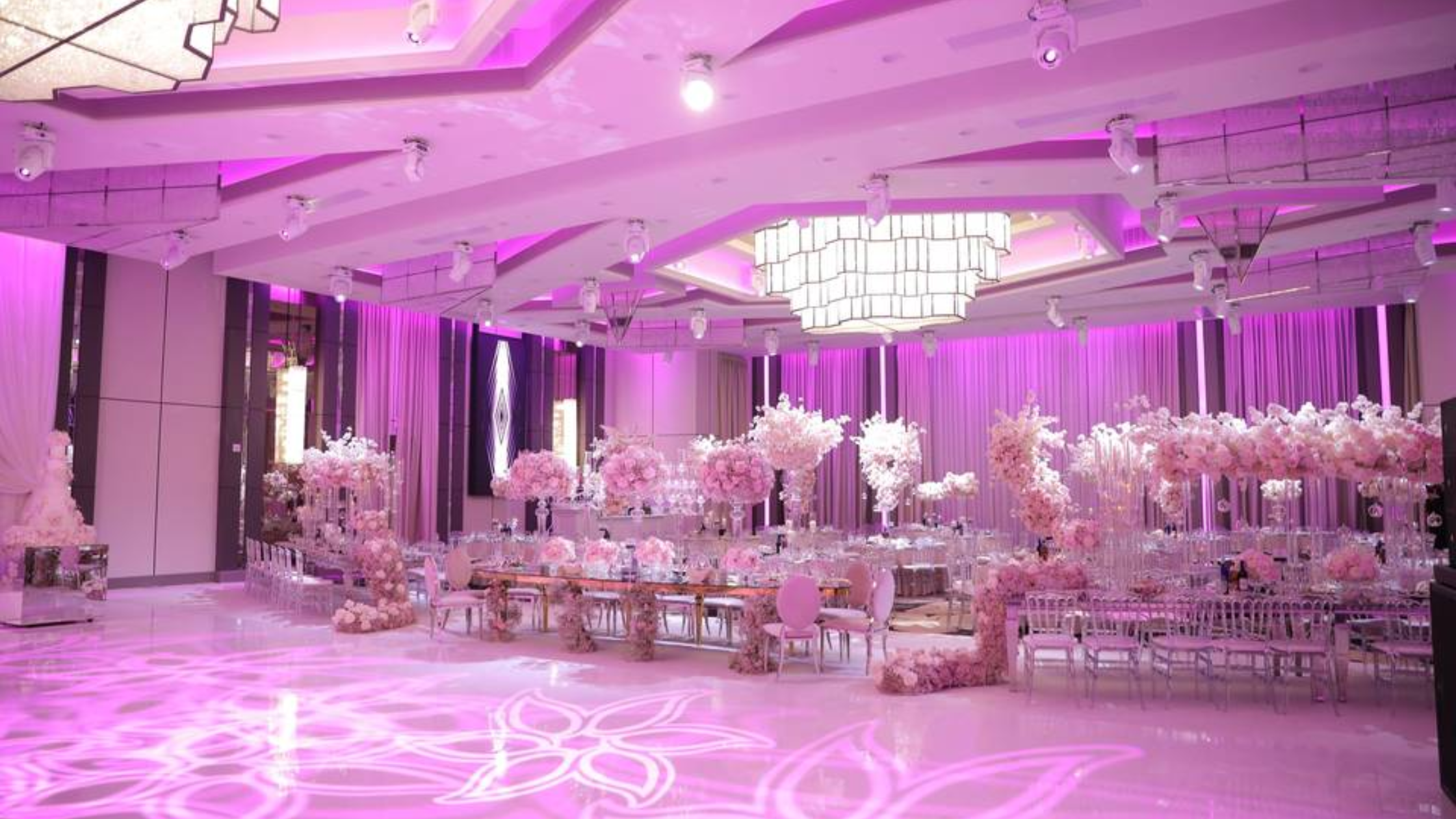 LA Banquets - Bronson Hospitality An elegant ballroom at LA Banquets featuring modern chandeliers, luxurious floral décor, soft ambient lighting, and a sophisticated indoor reception setting