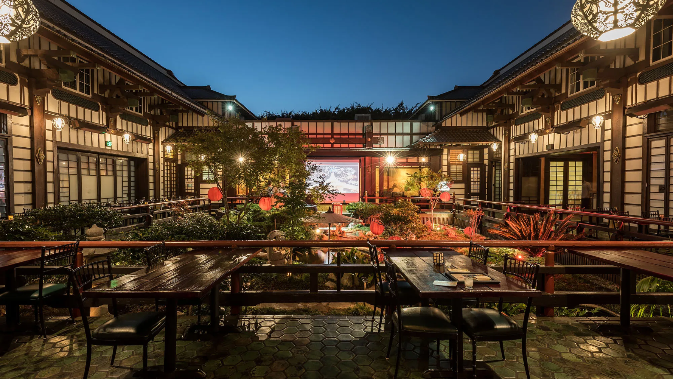 Yamashiro - Bronson Hospitality A stunning outdoor courtyard at Yamashiro featuring Japanese-inspired architecture, lush gardens, warm ambient lighting, and an elegant open-air setting with a serene atmosphere